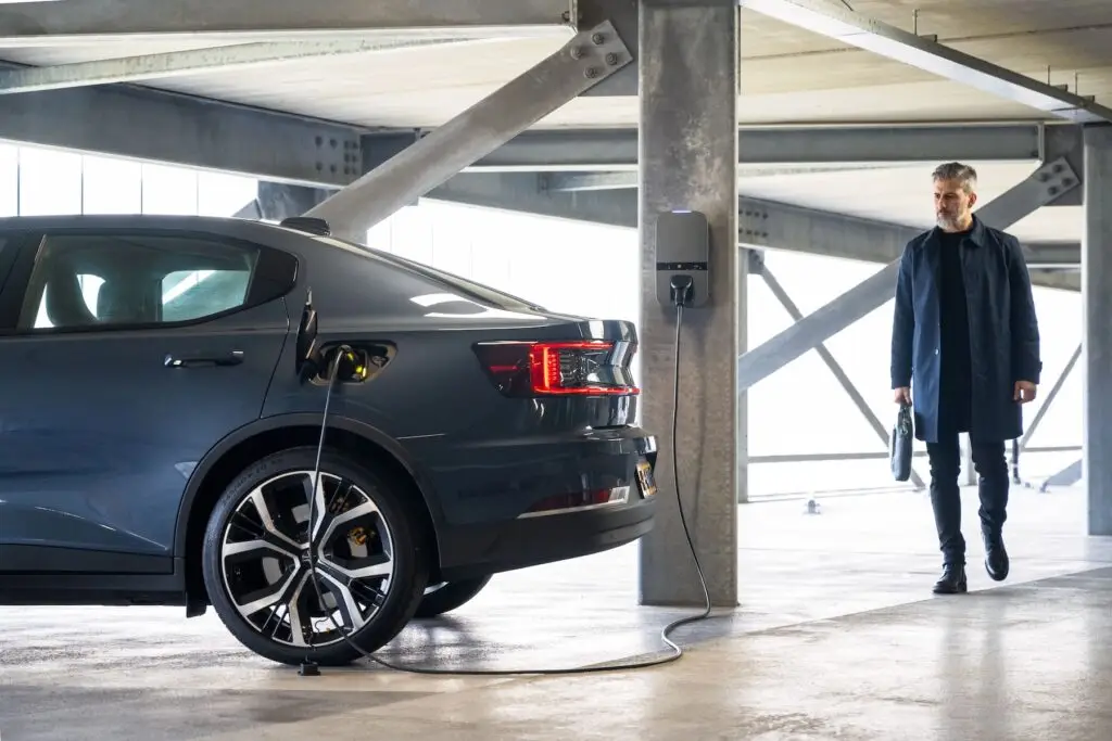 Laadstation in parkeergarage. Man loopt naar de aangesloten auto.